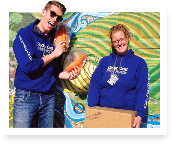 people posing with frozen fish and box