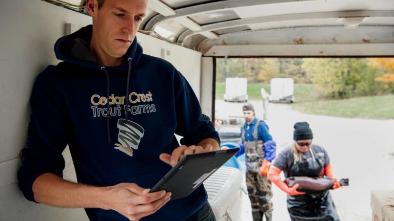 Man with tablet on fish farm