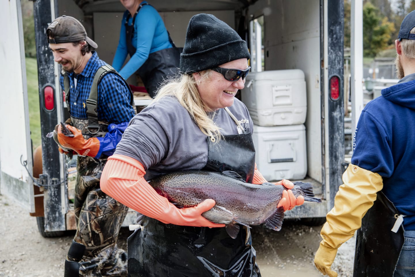 fish farmer woman holding rainbow trout