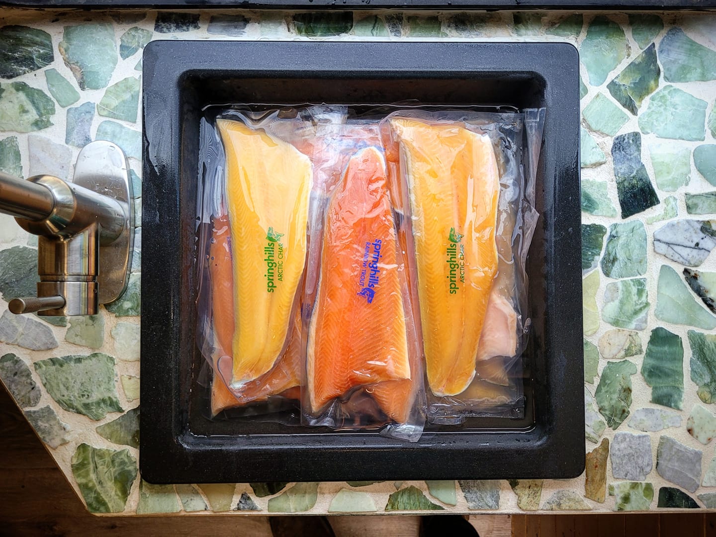 frozen trout and char fillets thawing in sink