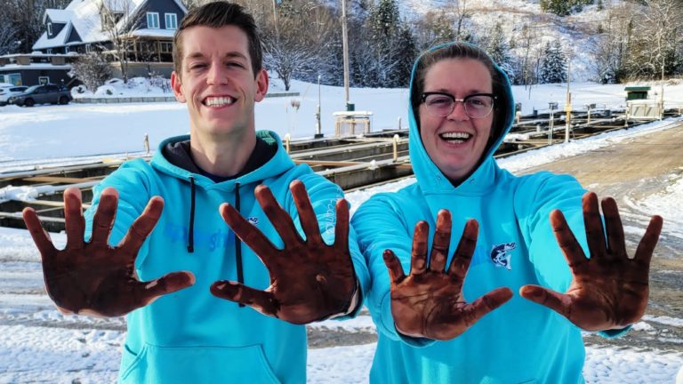 fish farmers posing with peat moss carbon on hands fish feed